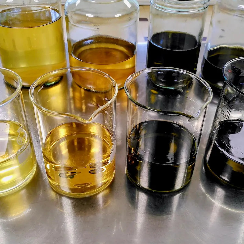 Béchers et flacons d'alcoolatures de plantes en préparation au laboratoire artisanal Lilja maris.